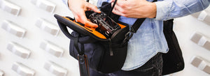 Utente che estrae la sua macchina fotografica da una borsa all'outlet