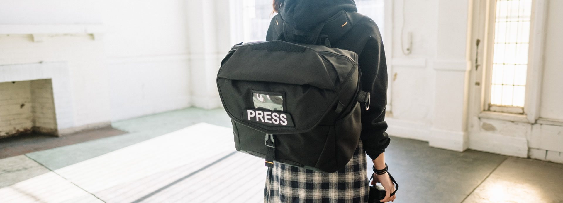 Reporter con una borsa fotografica sulla schiena