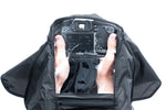 Mani e macchina fotografica nella copertura antipioggia per la macchina fotografica Vanguard Alta RCXL